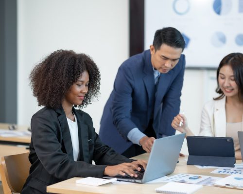 Group of young Asian businesspeople brainstorming meeting to discuss planning strategies new business development working on a new startup project in the office.